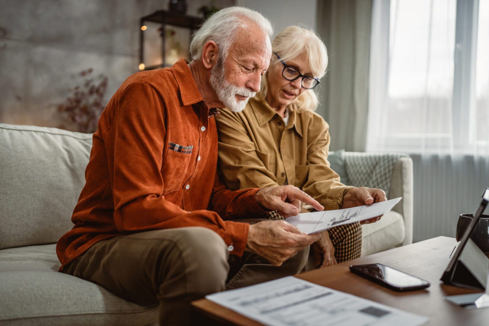 Senior unhappy couple do contactless payment and control bills on tablet